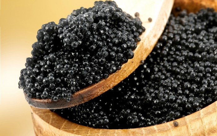 Caviar on a wooden spoon and in a bowl