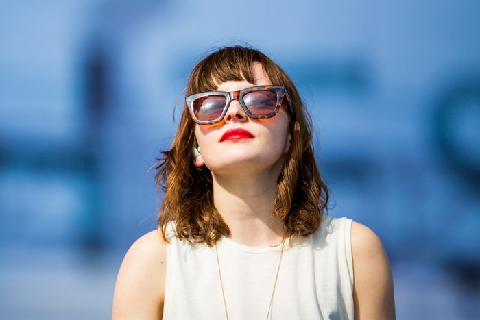 Lauren Mayberry wearing sunglasses and red lipstick