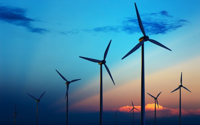 Wind turbines against a colorful sunset sky
