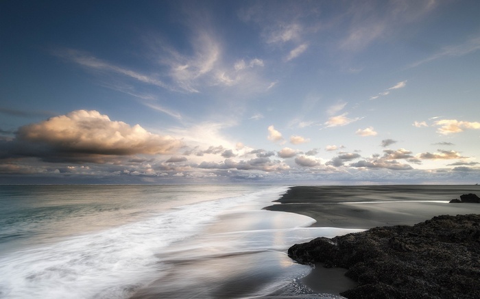 Long exposure of a beach with waves and clouds
