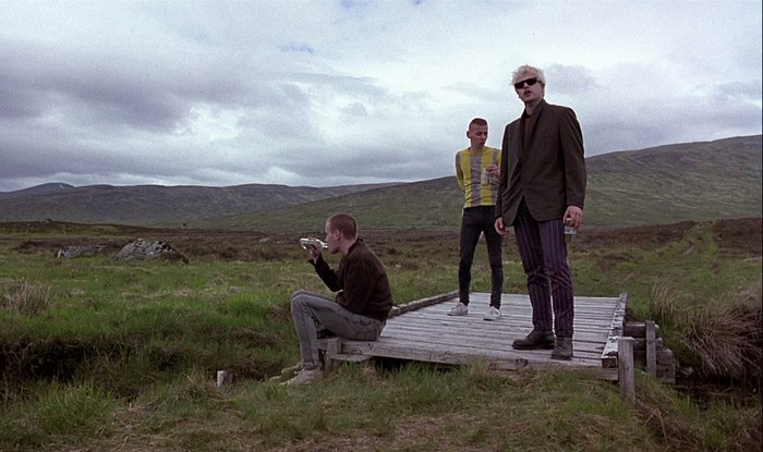 Trainspotting: Three men on a bridge in a landscape
