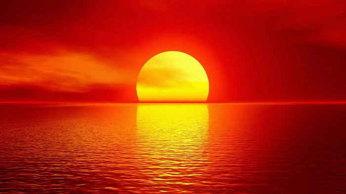 Bright Sun Setting Over Calm Ocean