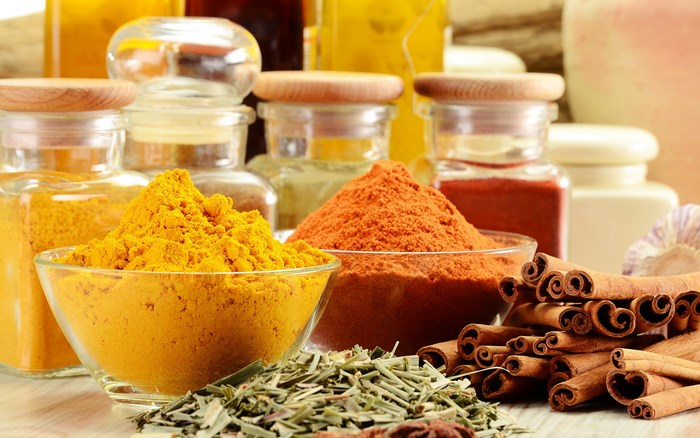 Various spices and herbs in glass jars and bowls