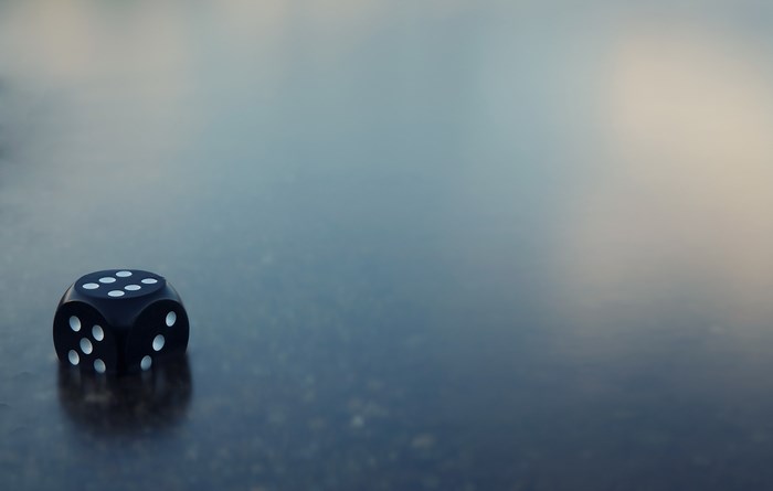 Black die with white dots on wet surface