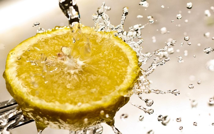Lemon slice being washed with water