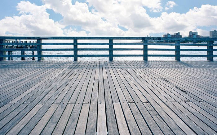 Wooden pier overlooking the ocean with city skyline