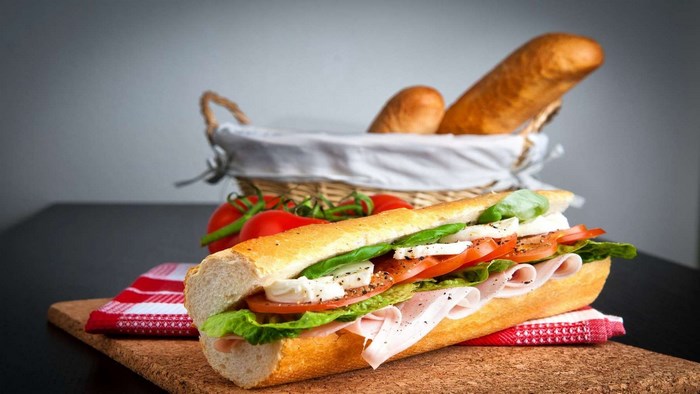 Sandwich with tomatoes and basil in a basket