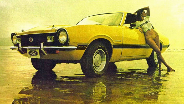Yellow Ford Maverick GT 302 V8 with woman on beach