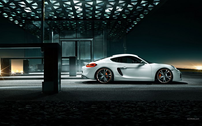 White Porsche Cayman parked under modern architecture