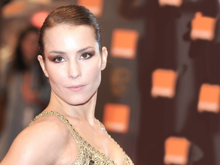 Noomi Rapace in a gold dress