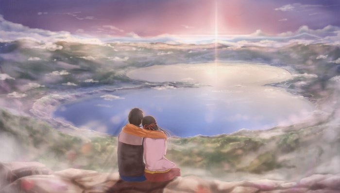 Couple watching sunset over a lake from a cliff