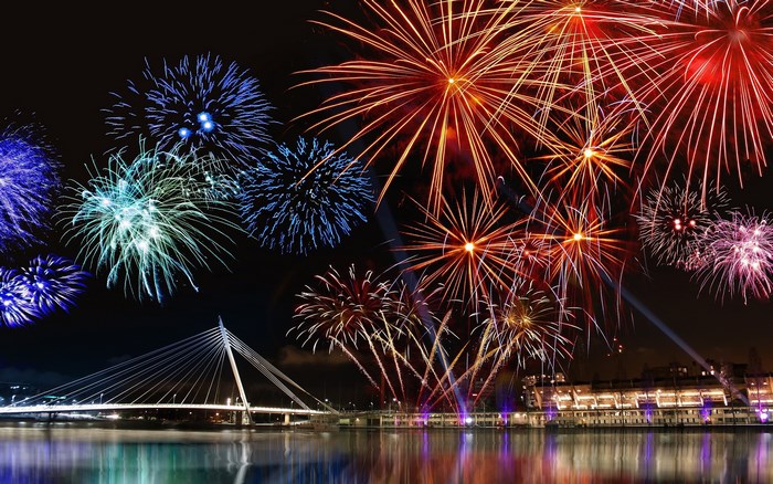 Fireworks over bridge and city at night