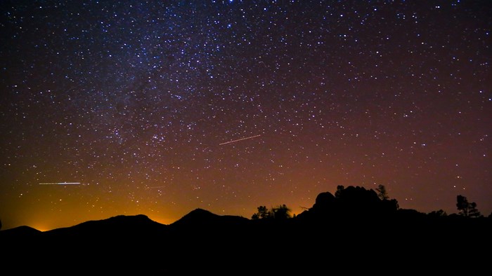 Night sky with stars and silhouette of mountains