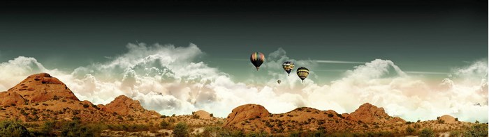 Hot air balloons over desert mountains