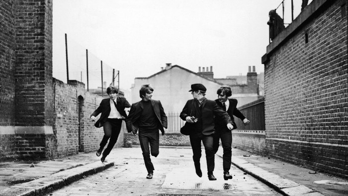 The Beatles running down an alley