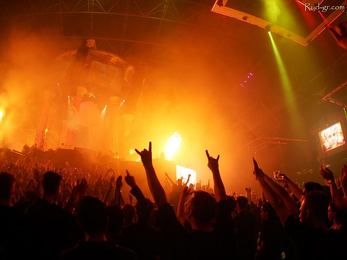 Concert crowd with hands raised and stage lights