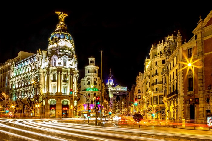 Metropolis Building and Rolex sign at night in Madrid