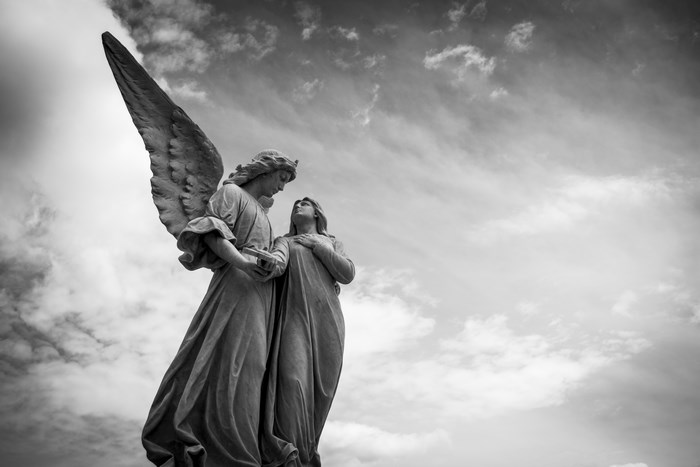 Angel statue looking at a woman