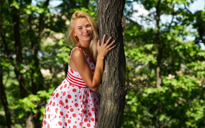 Woman in polka dot dress by tree