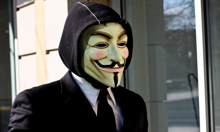 Person wearing Anonymous mask and suit