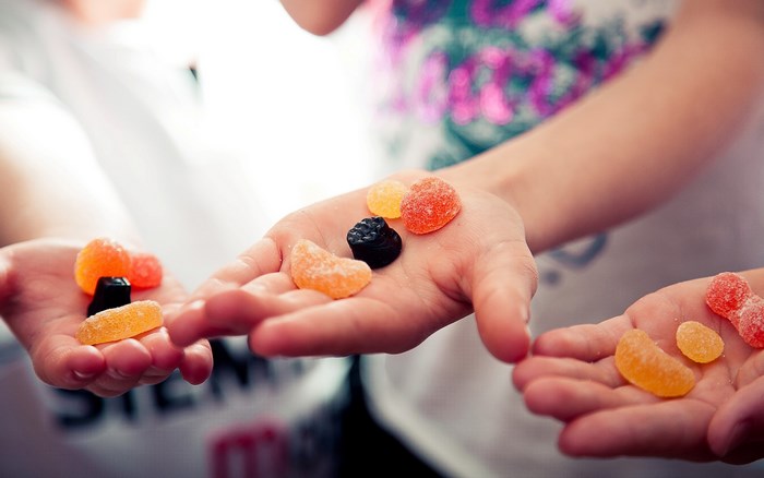Hands holding colorful gummy candies