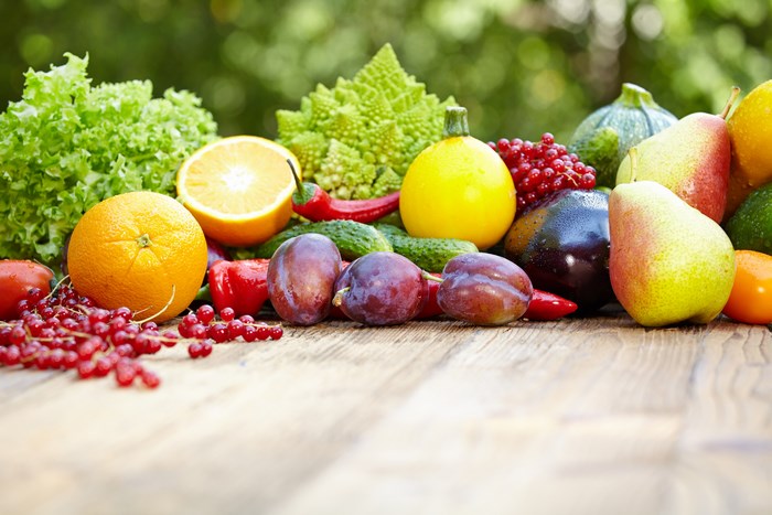 Assortment of fresh fruits and vegetables on a wooden table