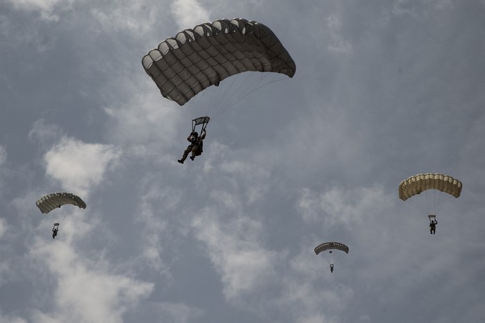 Paratroopers descending with parachutes