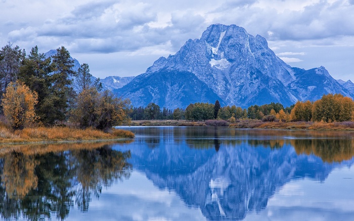 Mountaintop reflected in a calm lake with autumn trees
