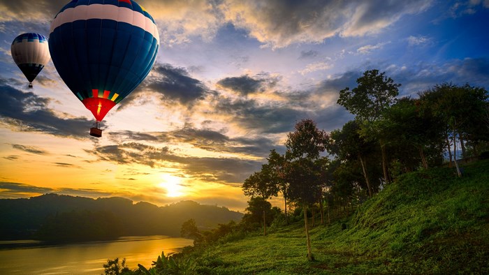 Hot air balloons over a lake at sunset