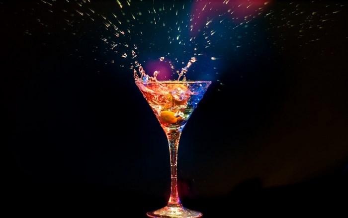 Cocktail splash with colorful lights