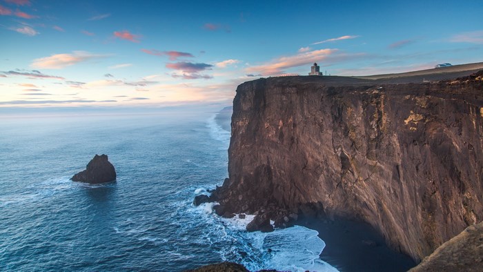 Cliff overlooking the ocean with a lighthouse