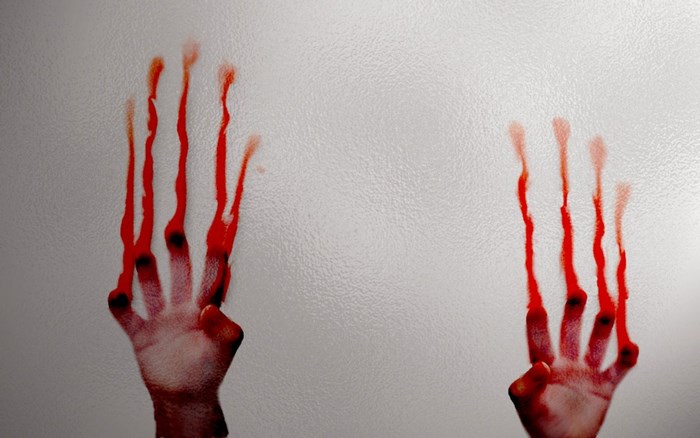 Bloody handprints on a textured surface