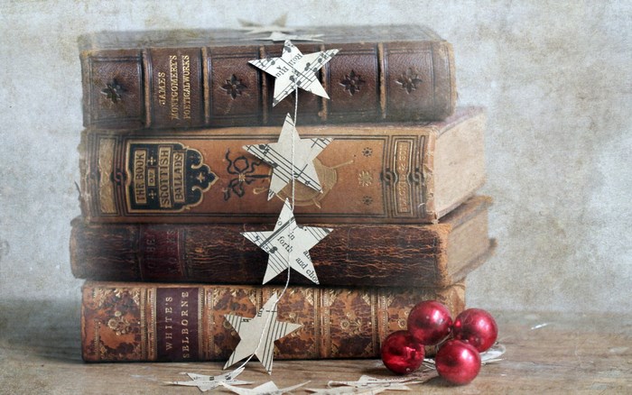 Stack of antique books with star garland and ornaments