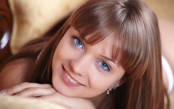 Close-up portrait of smiling young woman with blue eyes