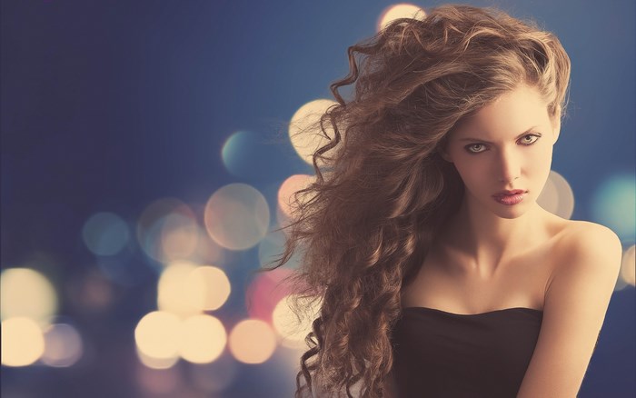 Elegant Woman with Flowing Curly Hair at Night
