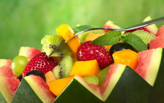 Fruit salad in watermelon bowl with fork