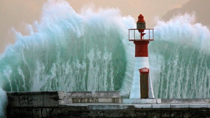 Lighthouse in front of a giant wave
