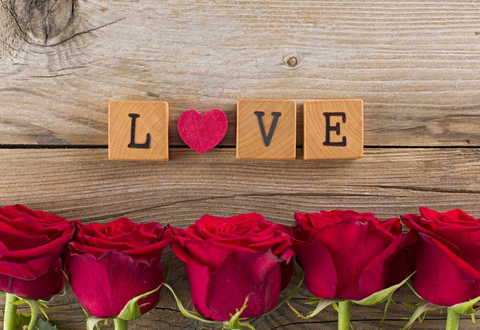 Wooden blocks spelling LOVE with red roses