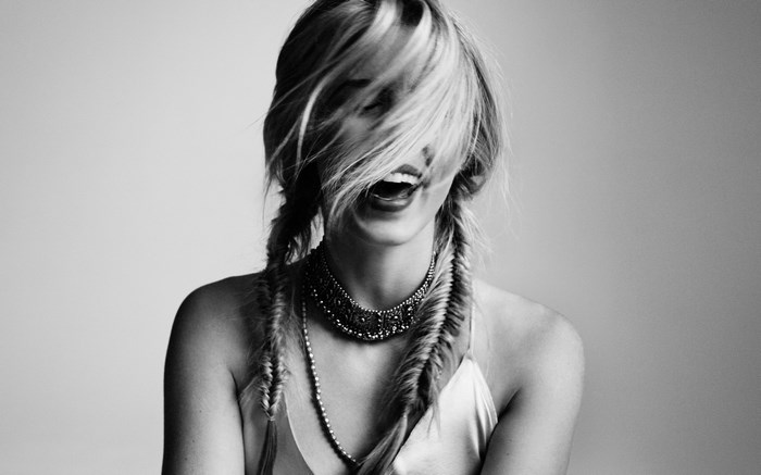 Emily Bett Rickards laughing with hair covering face