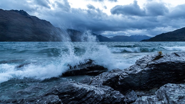 4K stormy lake with waves crashing on rocks