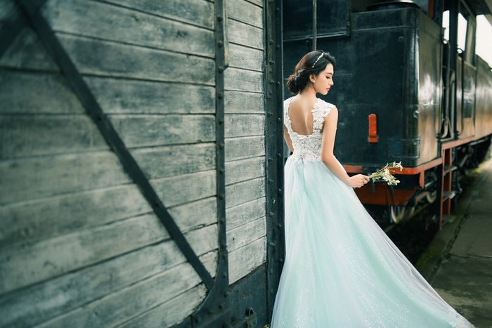 Bride in a light blue dress by a train
