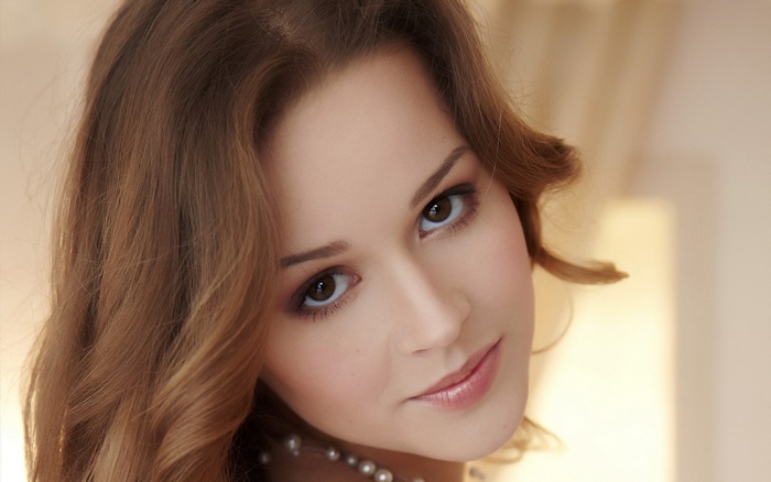 Close-up of a Smiling Woman with Pearl Necklace