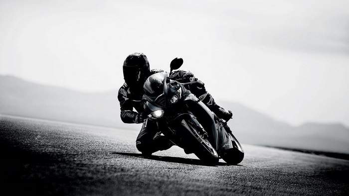 Motorcyclist leaning into a turn on a road