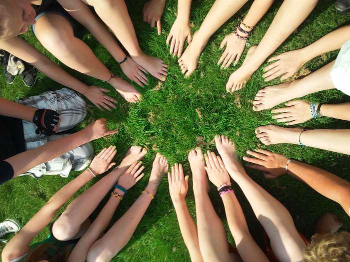 Group of friends sitting in a circle on grass
