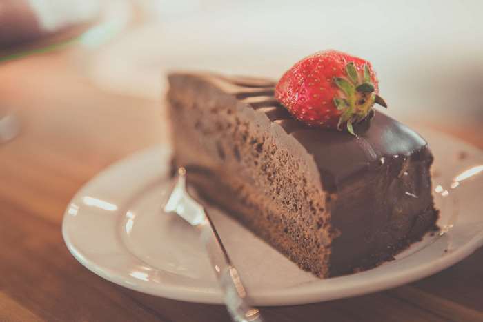Slice of chocolate cake with strawberry on a plate