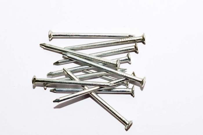 Pile of silver steel nails on white background