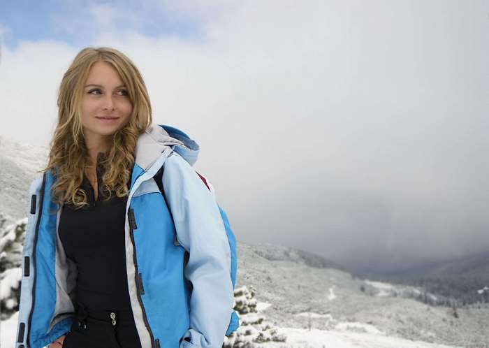 Woman in blue jacket in snowy mountains