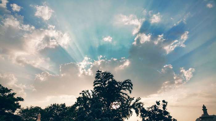Sunrays through clouds over trees