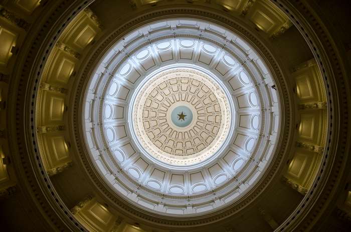 Interior of a domed building with a star emblem