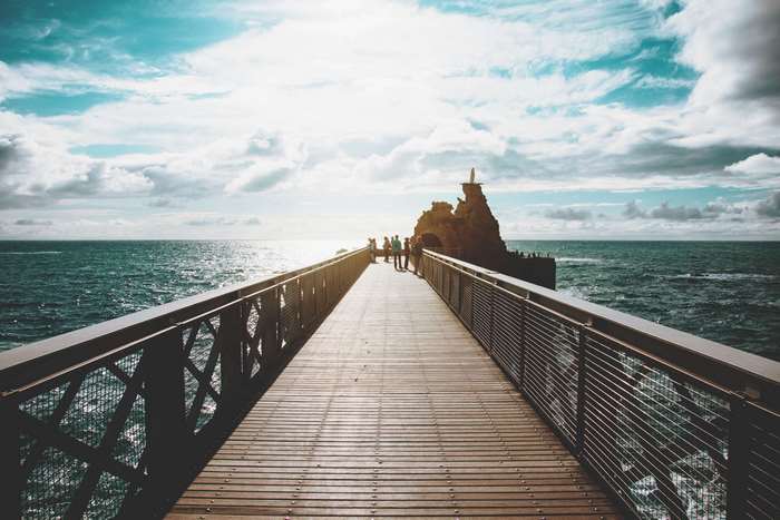 Wooden pier leading to a rocky outcrop in the ocean